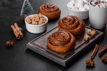 Freshly baked cinnamon roll with spices and cocoa filling on a black background