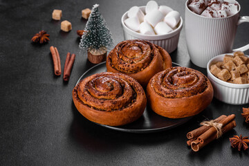 Freshly baked cinnamon roll with spices and cocoa filling on a black background