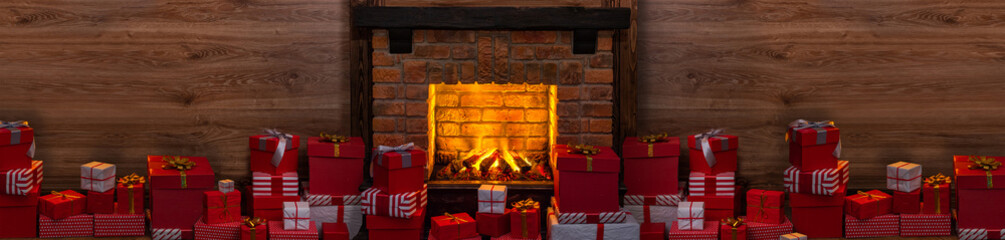 Many gift boxes near the Christmas fireplace in a festive interior of Log Cabins with wooden walls....