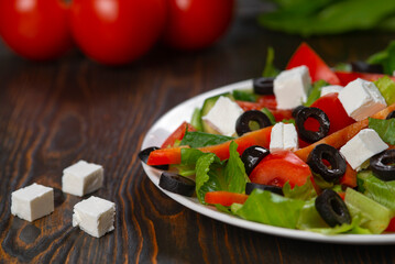 Greek salad. Vegetable salad with tomato, cucumber, salad leaves, feta cheese and olive oil.