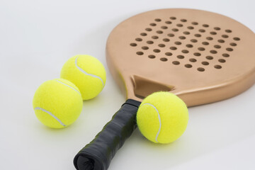 a paddle racket and three balls on a white background.