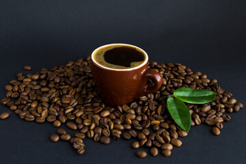 Coffee cup and roasted coffee bean on the black background.  Close-up.Copy space.