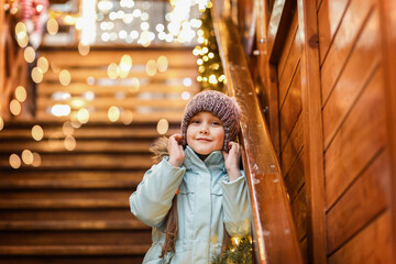 happy little girl at christmas market in winter evening. Cozy fair and New Year in Poland