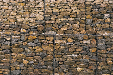 Wire gabions made of stones protect the walls from collapse in a landscape project. Stone gabions in landscape design as decorative textured elements in the arrangement of terraces.
