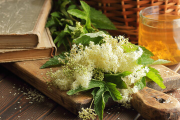 Meadowsweet herb, bouquet of flowers   on the wooden rustic table, antiviral homemade drink,...