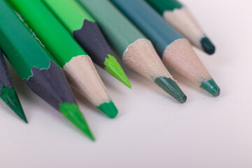 Fototapeta premium colored pencils on a white background. insulated pencils. wooden sharp pencils. background of colored green pencils