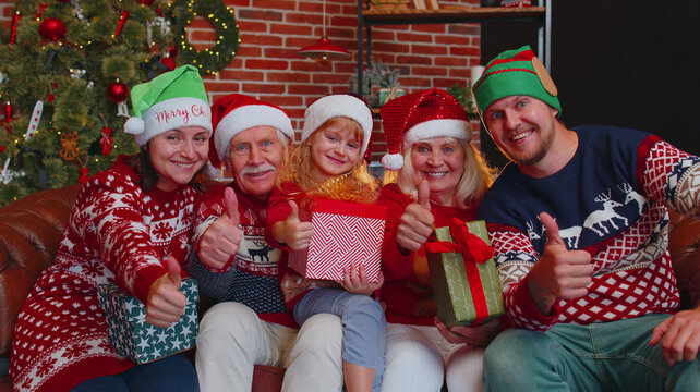 Cheerful smiling Caucasian multigenerational family taking selfie photo shot on timer mobile phone at decorated Christmas home, celebrating New Year together. Grandparents, mother, father, daughter