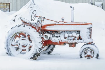 Wandaufkleber An old antique tractor covered in snow. © V. J. Matthew