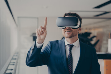Smiling bearded businessman in 3d goggles using augmented reality in work