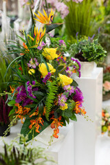Fototapeta premium Floral interior decor, artificial bouquet of flowers yellow rose green fern on a white pedestal