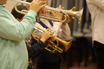 Group of children students of music college players young musicians standing playing a musical instrument trumpet at a jazz band class