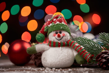 cheerful snowman in a knitted hat on a Christmas background.