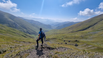 A man watching the sharp mountain peaks of the Chaukhi massif form the Chaukhi Pass in the Greater...