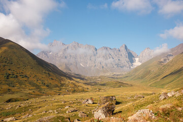 A panoramic view on the sharp mountain peaks of the Chaukhi massif in the Greater Caucasus Mountain Range in Georgia, Kazbegi Region. The valley is full of the Roshka stones. Georgian Dolomites.