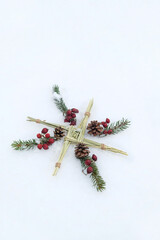 Brigid's cross, fir branches, berries in snow. symbol of Imbolc sabbat. ireland handmade amulet...