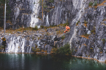 a man bungee jumping in the ruskeala mountain park in Karelia