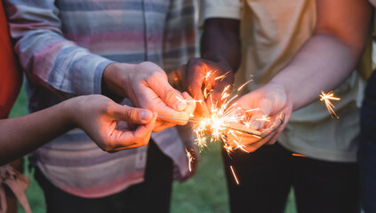 Happy friends celebrating together with sparklers on new year eve