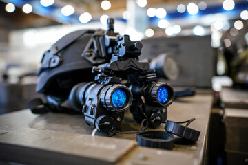 Fototapeta na wymiar Night vision goggles on military helmet, closeup detail to blue reflective lenses