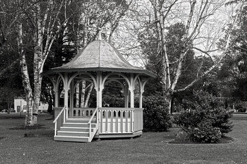 The gazebo at Washington Park in Oxford, NY in Black and White in Early Autumn.  Leaves have...