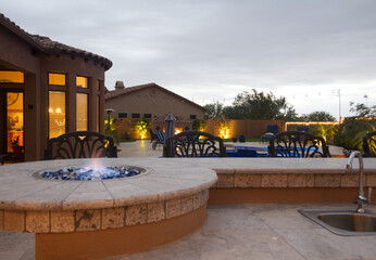 A Desert landscaped backyard in Arizona consisting of and outdoor BBQ, pool, spa and outdoor fireplace.