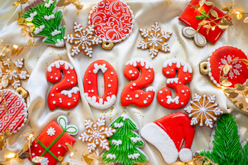 Banner for Christmas and New Year gingerbread cookies numbers 2023, snowflakes, Santa hat, Christmas trees, garlands on white silk fabric background