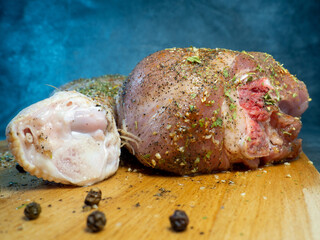 Turkey drumsticks in spices lie on a kitchen cutting board. Poultry meat.   Juicy meat is waiting to be cooked. Waiting for the oven.