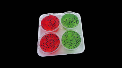 Green and red basil jelly candy on foam paper isolated on black background with clipping path.