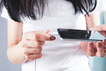 girl inserts the charging connector into the phone