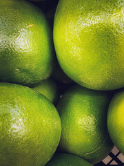 A lot of green citrus in the box