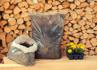 Agrotematics: presentation of packaging with soil, soil, fertilizer against the background of a wall made of birch firewood