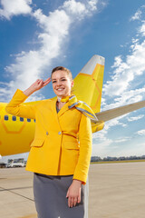 Cheerful woman stewardesses saluting outdoors at airport