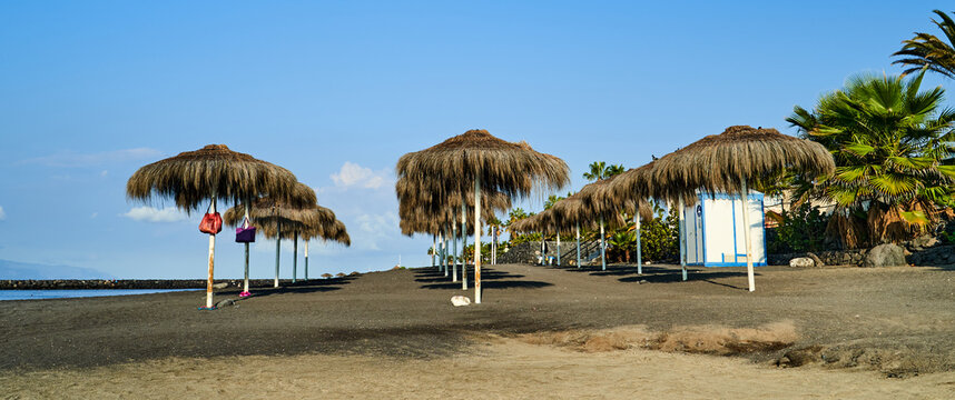 Sun umbrellas on the beach of Playa El Beril, Costa Adeje, Tenerifa