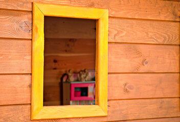 Widok przez okno drewnianego ogrodowego domku . View through the window of a wooden garden house . - obrazy, fototapety, plakaty
