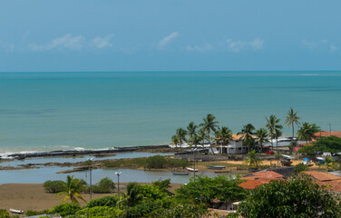 vista de cima de pria com muitas pedras que desaparecem com a maré alta