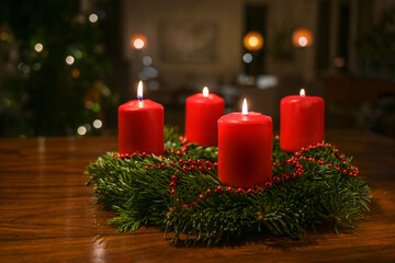 Small Advent wreath from fir branches with red burning candles and a simple Christmas chain on a...