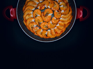 Fresh Mediterranean prawns in a pan on a black background