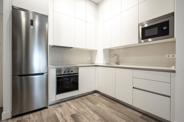 White kitchen with stainless steel appliances in a vacation rental loft