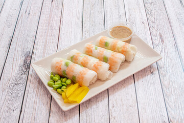 Glass uramaki sushi tray with prawns, edamame beans, yellow pepper and dip sauce
