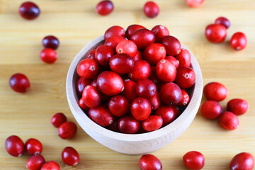 Red, fresh cranberries in a wooden bowl
