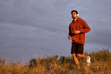 fitness runner man running on field training for marathon alone, run doing high intensity interval...