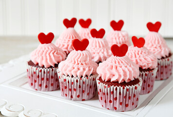 Red velvet cupcakes with pink frosting and a red heart