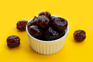 Sweet chinese jujube dessert in cup on yellow background.