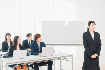 セミナーの講師とスーツ姿の男女
