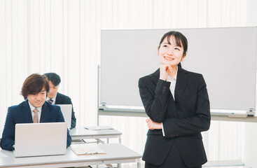 セミナーの講師とスーツ姿の男女（考える・アイディア）
