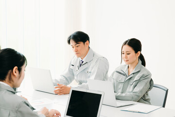 会議をする作業着をきた会社員
