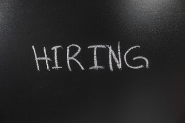 The Word hiring Was Written On The Chalkboard. Hiring concept.