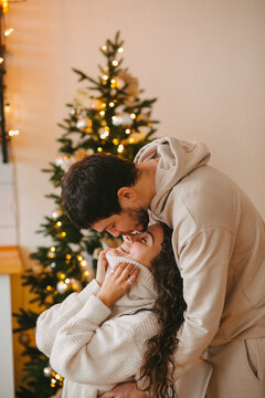 Young couple in a house in a romantic winter landscape in a christmas interior.