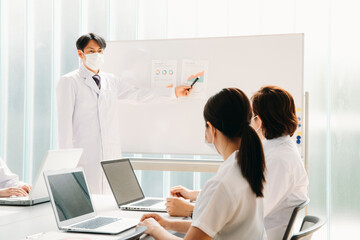 Obraz premium 会議する白衣姿の男女（マスク） 