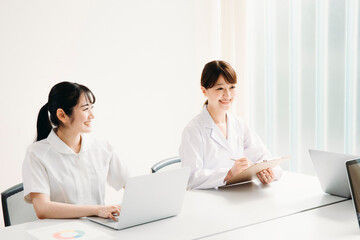 Obraz premium 会議する白衣姿の女性（笑顔） 