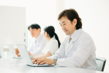 Fototapeta premium 白衣を着た男性（パソコン・笑顔） 